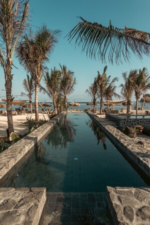 The pool and palms at Codium beach club, set back from the sand on Jalan Mawun